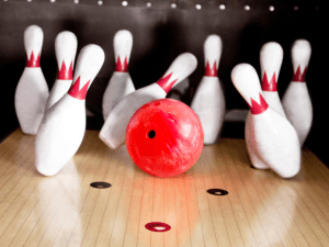 Red and white bowling pins with red ball.