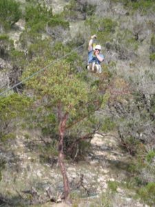a man on a zip line over a canyon