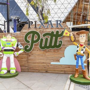 buzz lightyear and woodie the cowboy from Toy Story in front of a sign