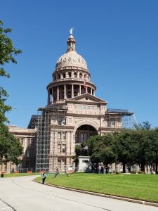 the capitol building of Texas red granite with trees in front