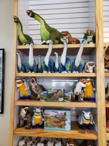 stuffed animals and dinosaurs on shelves