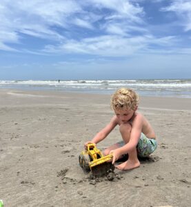 Little boy playing in sand at beach